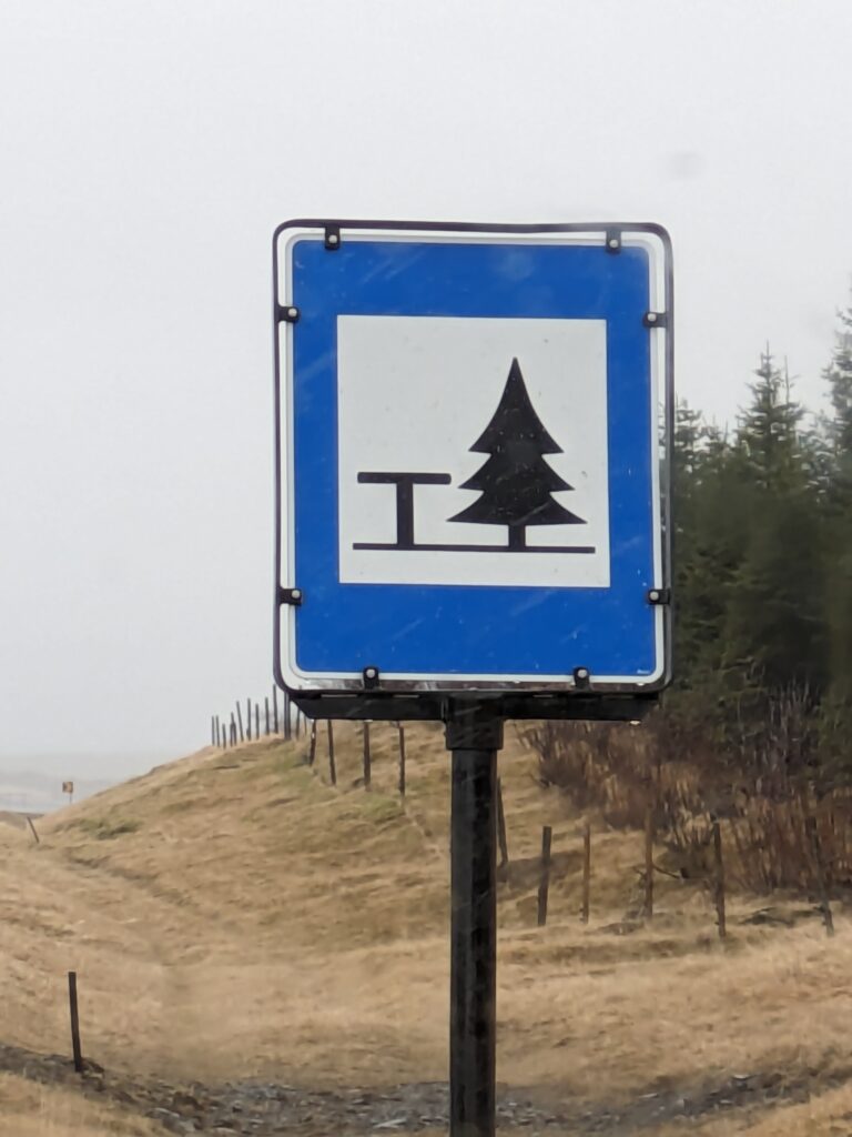 A sign with a tree in the background