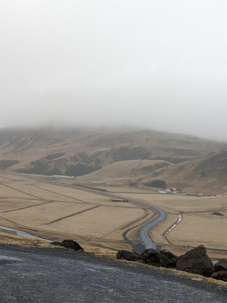 Scenic view of a road disappearing into a fog-covered valley